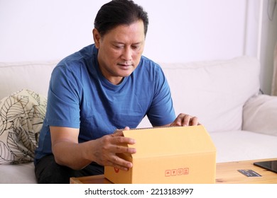 The 40s Adult Asian Man Opening The Mail Box In The Living Room.