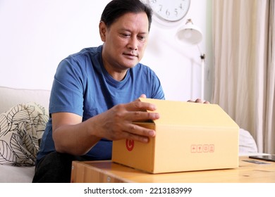 The 40s Adult Asian Man Opening The Mail Box In The Living Room.