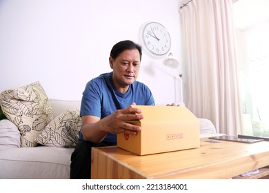 The 40s Adult Asian Man Opening The Mail Box In The Living Room.