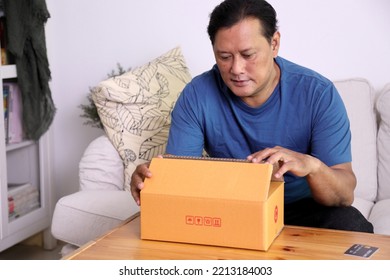 The 40s Adult Asian Man Opening The Mail Box In The Living Room.