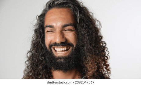 40s man with long curly hair look camera. Happy young adult guy portrait. One 30 year old cute person. Nice wavy beard close up. Male arab face head shot. Mixed hindu model smile. Nose piercing style - Powered by Shutterstock