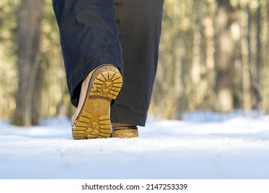 A 40s Wooman Walks In The Snow In Winter Forest. Woman Walking On Snow In Winter Forest. Focus On Sole Of Show With Snow.