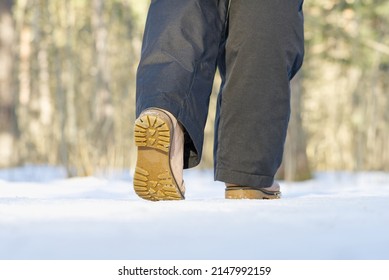 A 40s Wooman Walks In The Snow In Winter Forest. Woman Walking On Snow In Winter Forest. Focus On Sole Of Show With Snow.