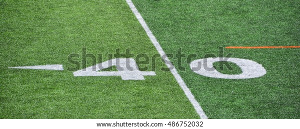 The 40-yard-line of an american football field with\
artificial turf