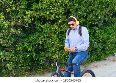 40-year-old Man Listening To Music On His Cell Phone While Riding His Bike