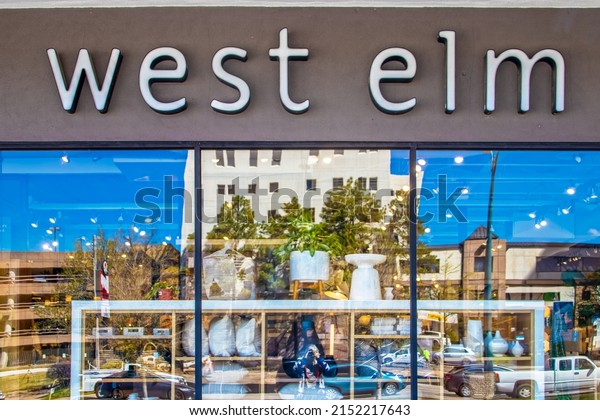 4-23-2022 Tulsa USA\
West Elm storefront and sign with blurred reflection of merchandise\
and buildings and\
traffic