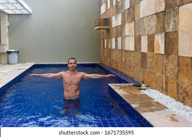 44 Year Old Man, With Six Pack Abs, In The Pool And With Open Arms.