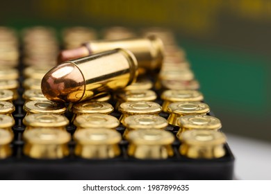 .45 ACP bullet pistol gun with green army ammo box background