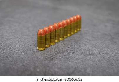45 ACP caliber full metal jacket bullets unfired rounds lined up on a stone surface