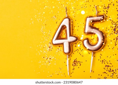 45 years celebration. Greeting banner. Gold candles in the form of number forty five on yellow background with confetti. - Shutterstock ID 2319080647