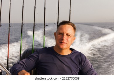 A 45-46-year-old Man Is Traveling At Speed Across The Sea On A High-speed Boat. The Wind Blows In His Face. The Concept Of Freedom.