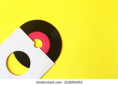 45rpm Vinyl Record With Sleeve. Close Up Vinyl On Yellow Background. 