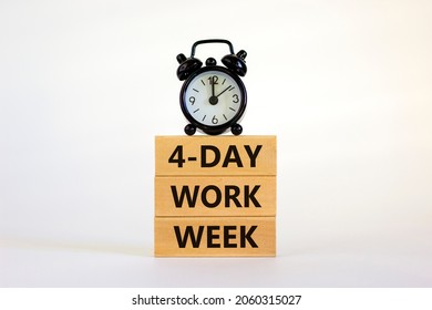 4-day work week symbol. Concept words '4-day work week' on wooden blocks. Black alarm clock. Beautiful white background. Copy space. Business and 4-day work week concept.