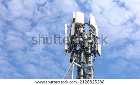4G and 5G Cellular Base Station. Base Transceiver Station (BSC) Radio transceiver with cell phone in cellular wireless communication system on metal towers on cloudy sky background with copy space.