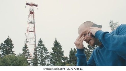 4G And 5G Cellular Radio Tower, The Man Has A Bad Headache. The Concept Of Harmful Effects Of Powerful Radio Waves, High Frequency On Human Health