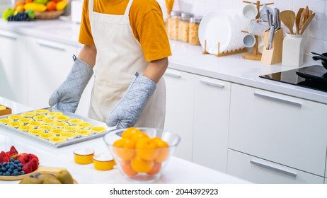 4K Asian Man Bakery Shop Owner Preparing Bakery In The Kitchen. Male Baker Baking Tart Dough For Making Fruit Tart On The Table. Small Business Entrepreneur And Indoor Activity Lifestyle Concept.