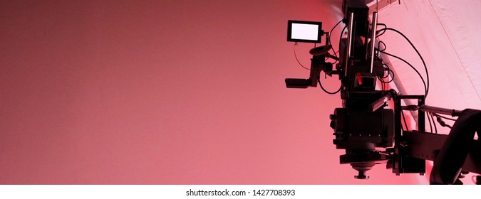 4K high definition video camera monitor on tripod or crane in studio and softbox paper and professional lighting equipment for shooting or filming or broadcasting content to advertising commercial 