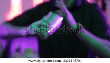 4K Professional male bartender pouring mixed blue liquor cocktail drink from cocktail shaker into shot glass on bar counter at nightclub. Mixologist barman making alcoholic drink serving to customer