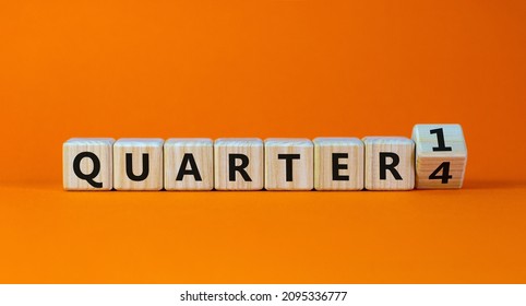 From 4th to 1st quarter symbol. Turned a wooden cube and changed 'quarter 4' to 'quarter 1'. Beautiful orange table, orange background. Business, happy 1st quarter concept, copy space.