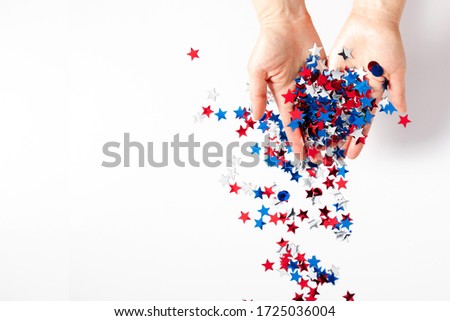 4th of July American Independence Day. Happy Independence Day, Female hands with decorations stars on white background. Flat lay, top view, copy space
