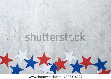 4th of July background. USA paper fans, Red, blue, white stars and confetti on gray old concrete wall background. Happy Labor Day, Independence Day, Presidents Day. American flag colors. Mock up.