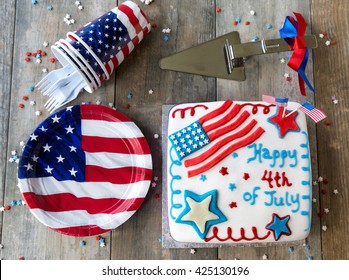 4th Of July Cake With Picnic Plates And Cups On Wooden Table, Seen From Above