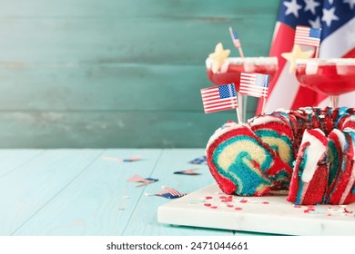 4th of July Holiday background. American flag color layered spounge cake bundt with glaze against background of turquoise old board and flag. Patriotic American Flag Dessert Cake. Mock up. - Powered by Shutterstock