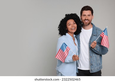 4th of July - Independence Day of USA. Happy couple with American flags on grey background, space for text - Powered by Shutterstock