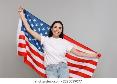 4th of July - Independence Day of USA. Happy woman with American flag on light grey background