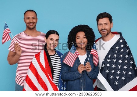 4th of July - Independence Day of USA. Happy friends with American flags on light blue background