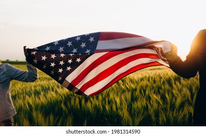  4th of july Patriotic holiday. Independence day. Hands holding american flag at sunse.  - Shutterstock ID 1981314590