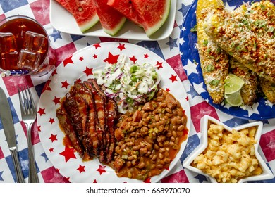 4th Of July Picnic Filled With Barbecue Brisket, Baked Beans, Coleslaw, Corn, Mac And Cheese, Watermelon And Iced Tea Shot From Above