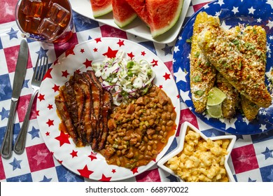 4th Of July Picnic Table Filled With Barbecue Brisket, Baked Beans, Coleslaw, Corn, Mac And Cheese, Watermelon And Iced Tea Shot From Above