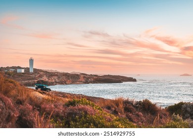 4WD car parked on rocky beach in Robe with driver enjoying the scenic sunset view with ocean, South Australia - Powered by Shutterstock