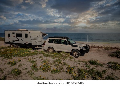 A 4WD And Modern Caravan Camping Alongside A Sunny Beach In Australia