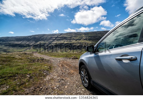 4WD\
SUV vehicle car running on gravel road with nature mountain\
landscape in Iceland. Adventure and extreme\
sport.