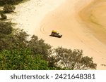 4WD trucks camping on the beach below Indian Head, a coastal headland on the eastern side of Fraser Island (K