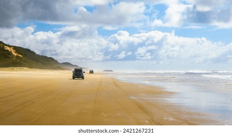 4WD trucks driving offroad on the Fraser island beach track near the SS Maheno shipwreck, half buried in the sand of the 75 mile beach on the east coast of the island in Queensland, Australia