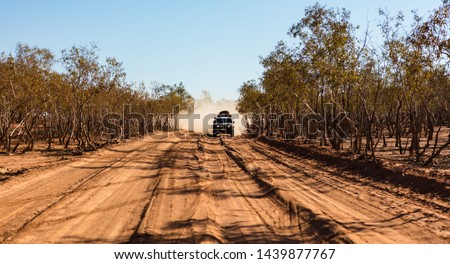 A 4wd vehicle approaches with a large dust cloud close behind it from the very dusty dirt tracks found in the Australian outback.