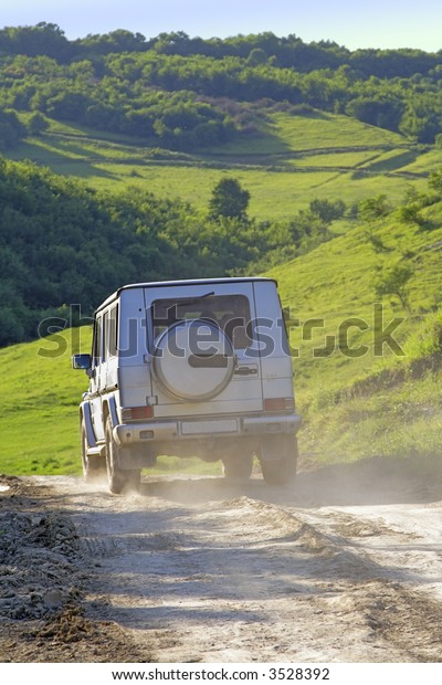 A 4X4 car\
on a outdoor road in a mountain\
region.