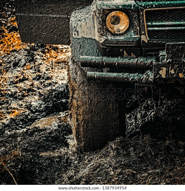 4x4 travel trekking. Offroad\
vehicle coming out of a mud hole hazard. Off-road travel on\
mountain road. Expedition offroader. Road adventure. Adventure\
travel