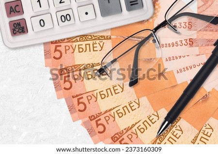 5 Belorussian rubles bills fan and calculator with glasses and pen. Business loan or tax payment season concept. Financial planning