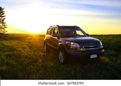 5 Door Compact Crossover SUV In The Countryside With Sunset In The Background.