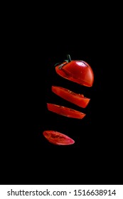 5 Flying Tomato Slices On A Black Background