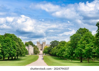5 June 2019: Windsor, Berkshire, UK - Windsor Castle, home of the British monarch, and the Long Walk, with its avenue of trees in full leaf, people walking along it, and a beautiful summer sky.