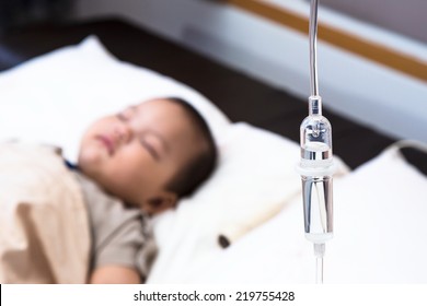 5 Months Old Baby With Dehydration, Receiving Medication Through Intravenous Fluid Therapy While Asleep In Hospital Bed, Focus On Drip Chamber