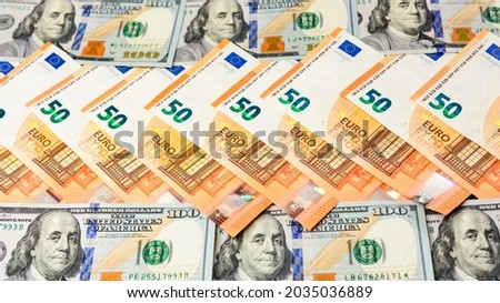50 euros and 100 dollars lie in a row, banknotes of euro and dollars on a black background. new