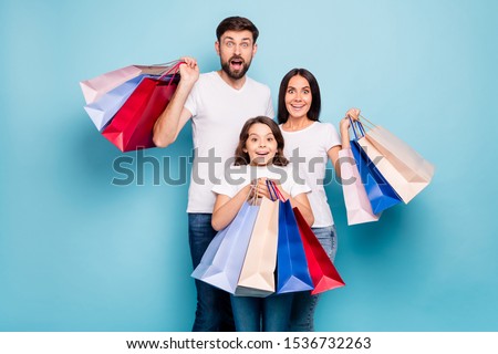 50% off! Real bargain concept. Portrait of excited three people mom dad schoolkid shop center hold bags scream wow omg wear white t-shirt denim jeans isolated over blue color background