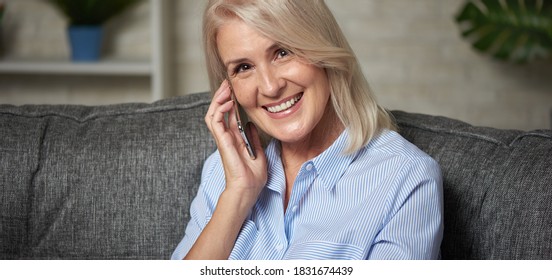 50 years old blonde woman is talking on phone. Retired lady at home - Powered by Shutterstock