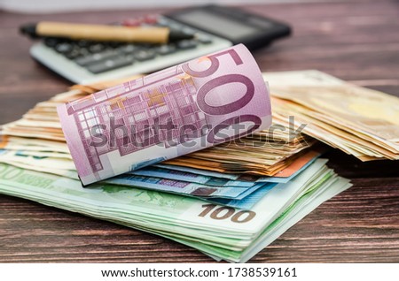 500 euro banknote rolled into a roll on the background of money and a calculator. Business concept.